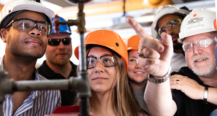 Students in hardhats learn about Safety Science equipment