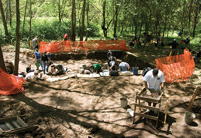 Students work at an archaeology dig