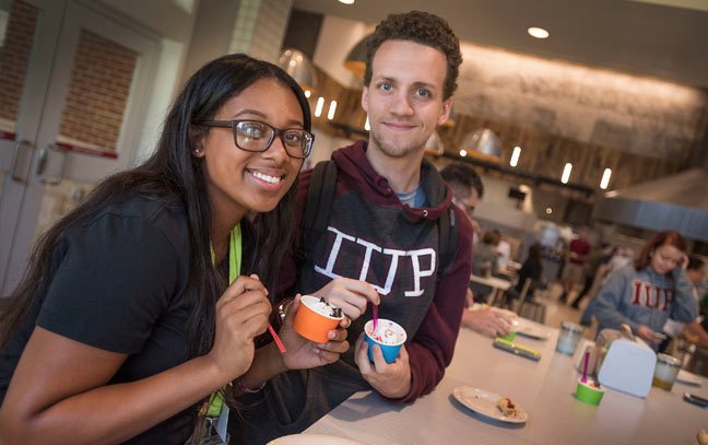 two students in the dining hall holding small cups of gelato
