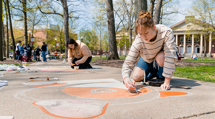 students drawing on the sidewalk in chalk