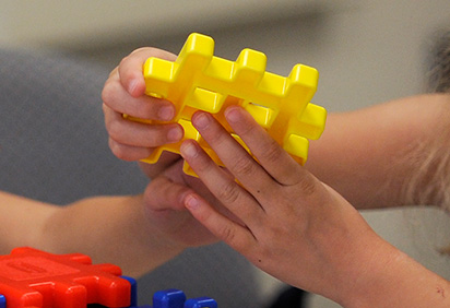 A child plays with a plastic block