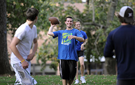 College student throwing football in the Oak Grove College student throwing football in the Oak Grove