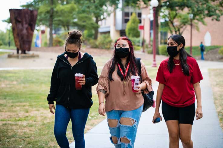 Three masked IUP students walking together through the Oak Grove 