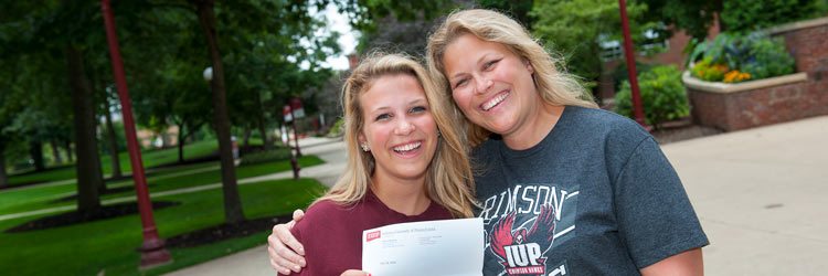 A mother and daughter hug in the Oak Grove as they celebrate the daughter's acceptance into IUP A mother and daughter hug in the Oak Grove as they celebrate the daughter's acceptance into IUP