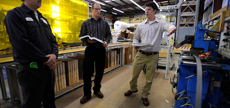 A Safety Science student points out a machine during at an internship site