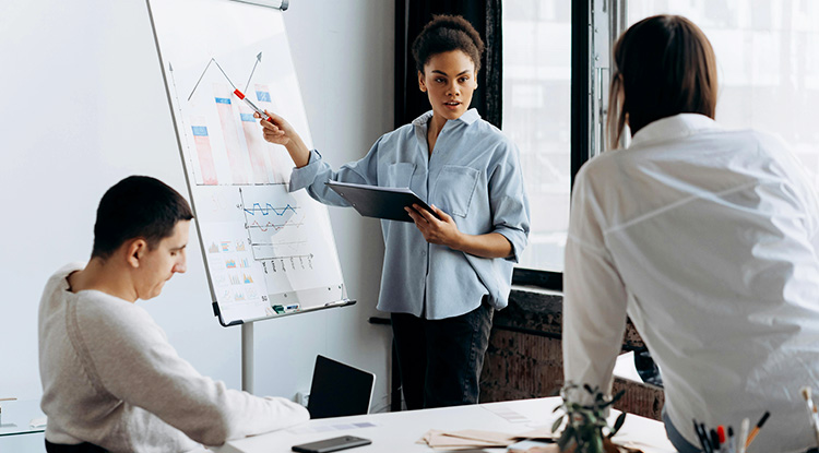 A woman presenting data to a group of colleagues