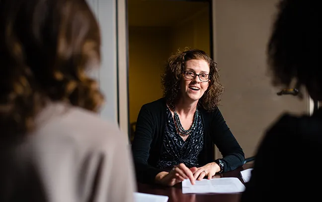 a professor speaks with two students