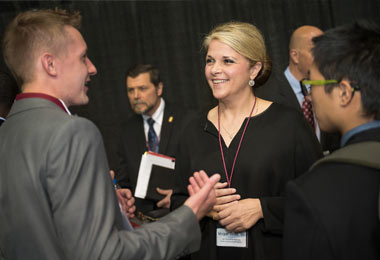 a man and woman speaking together in a crowd