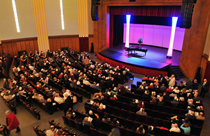 A view inside Fisher Auditorium just before a show with the audience mostly seated