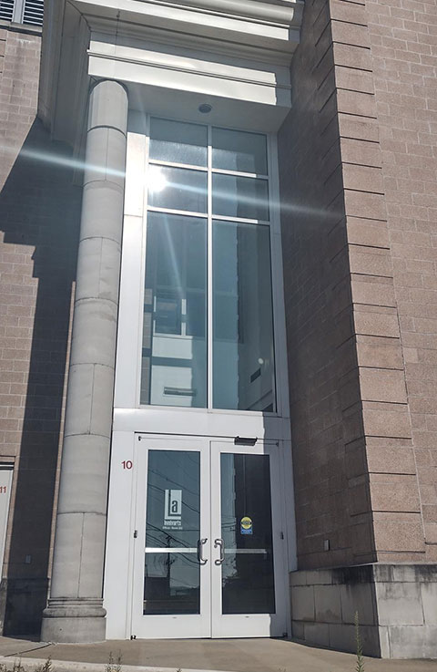 The tall glass outside door leading into the Lively Arts office.