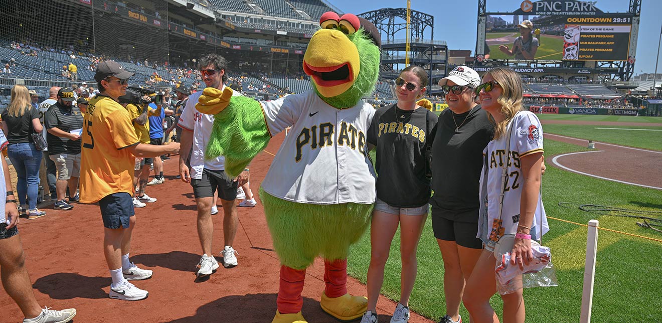 The Pirate Parrot and three IUP alumni on the field at PNC Park