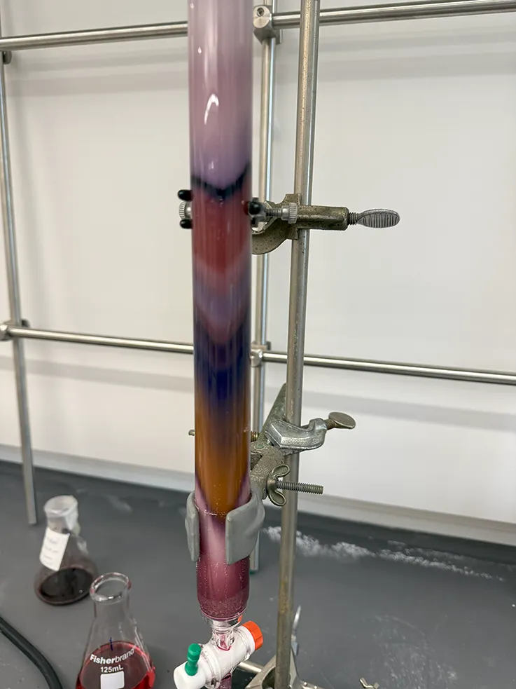 a glass vial filled with various colored chemicals