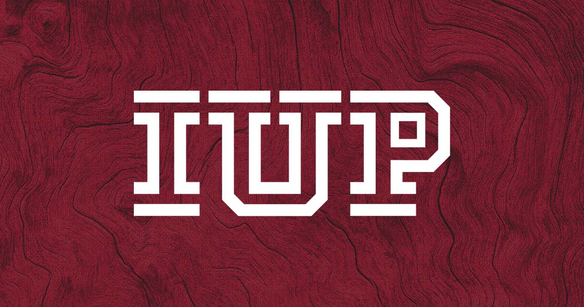 White IUP logo sitting on top of a red wood grain background