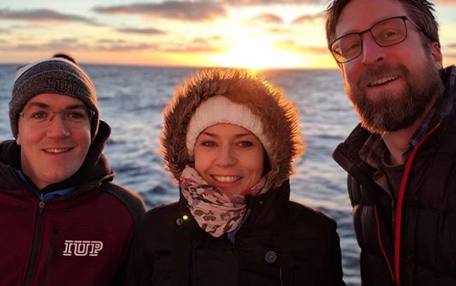An IUP researcher and two colleagues on a research ship in near Antarctica