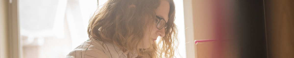 sideview of a female students face working at a desk