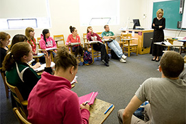Professor Kerr teaches a class of future teachers with their desks arranged in a circle.