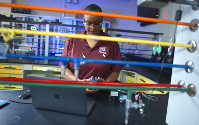 Black student researcher conducting an experiment in a science lab.