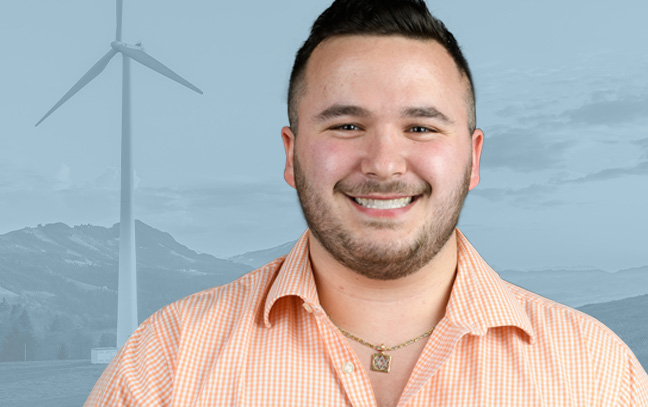 A student being superimposed in front of a blue background with a wind turbine.