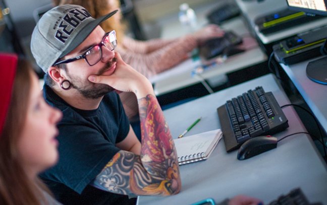 close up of a student working on a computer in a graphic design class