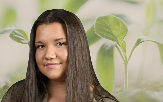 A student being superimposed in front of a background with plants.