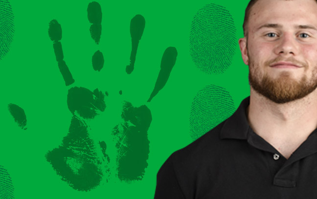 A student being superimposed in front of a green background with finger and hand prints.