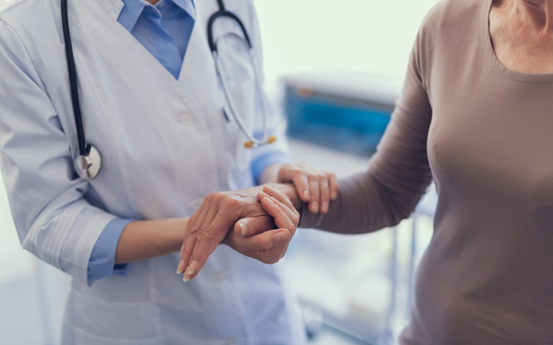 close up of a doctor holding a patients hand