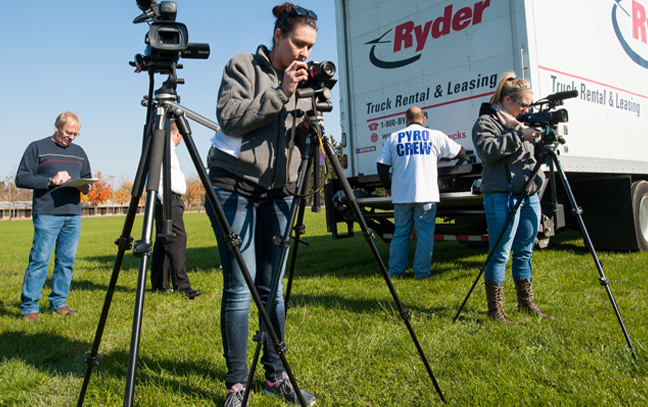 group of students preparing cameras in the field for a broadcast