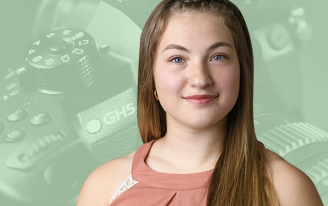 A student being superimposed in front of a green background with a camera.