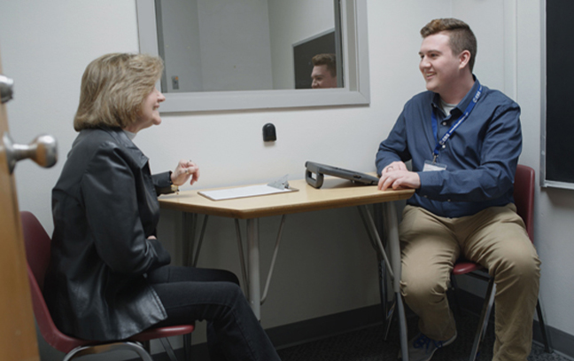 student and professor talking in the resource room