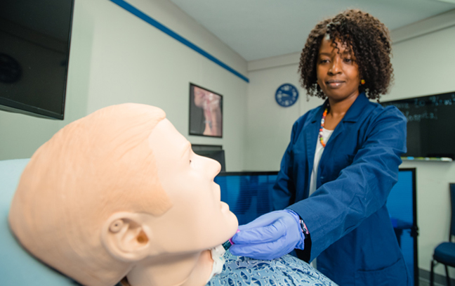 student taking a reading from a dummy in a lab setting