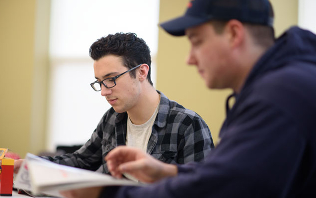 close up of a male student reading a document in a classroom