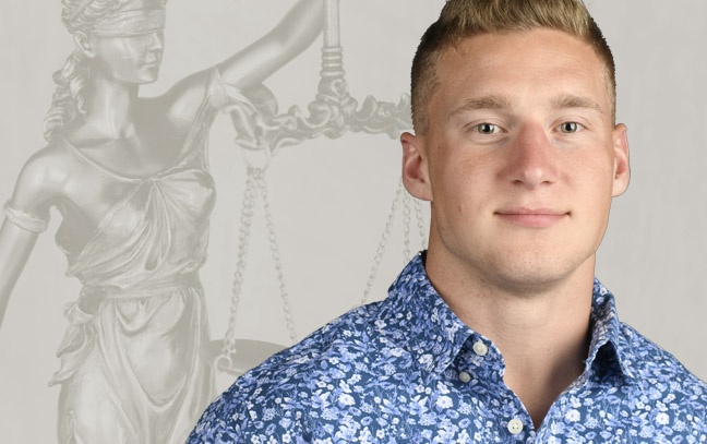 A student being superimposed in front of a gray background with a statue of lady justice.