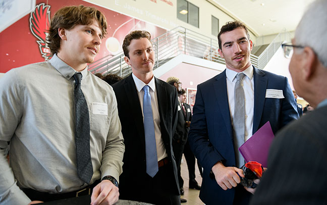 group of students talking to professionals during an event