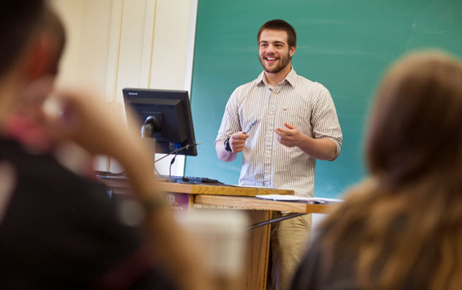 student presenting at the front of an english classroom