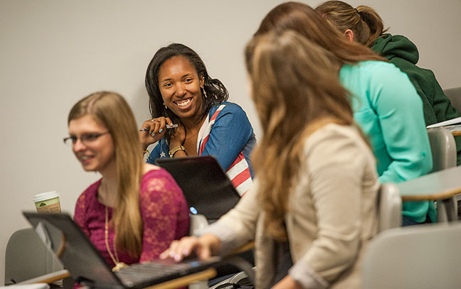 a group of students smile and talk during class