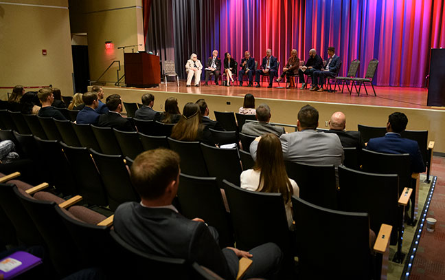 wide shot of a speaker and audience at an auditorium