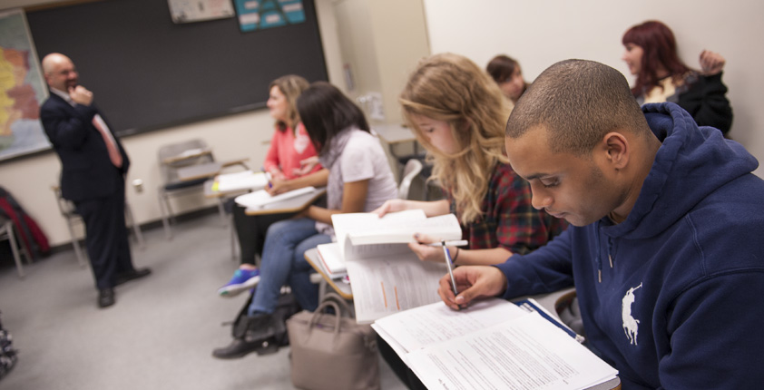 a group of students taking notes in a foreign languages classroom