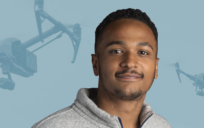 a male student superimposed in front of a teal backdrop with drones flying through the air