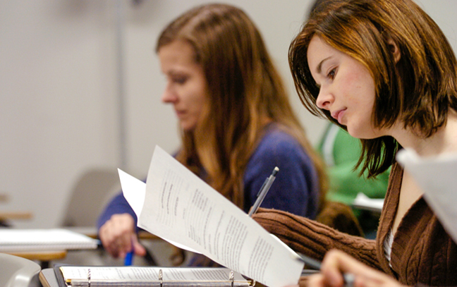 close up of female students looking over papers in a classroom