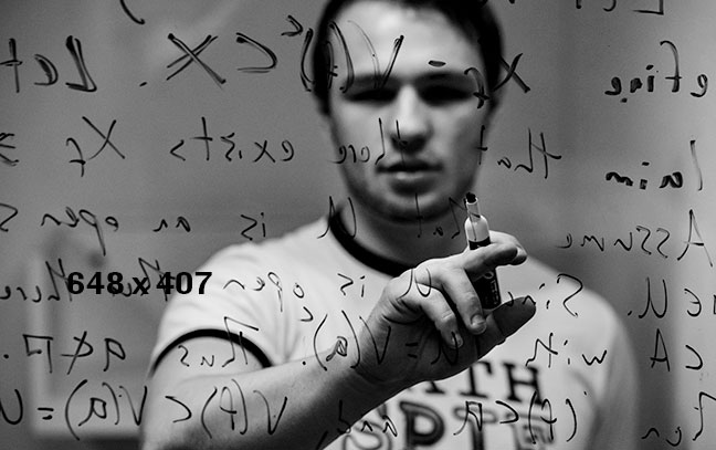 man writing math equations on board