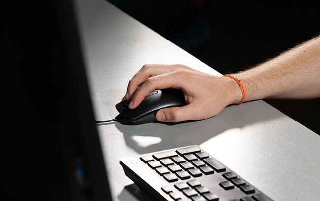 person's hand on mouse working on desktop