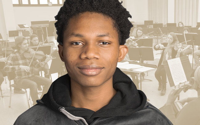 A student being superimposed in front of a muted yellow background showing an ensemble in a band room.