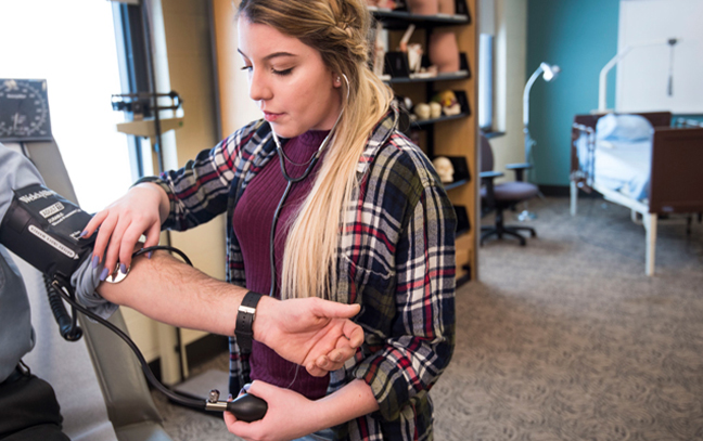 nursing student taking someone's blood pressure