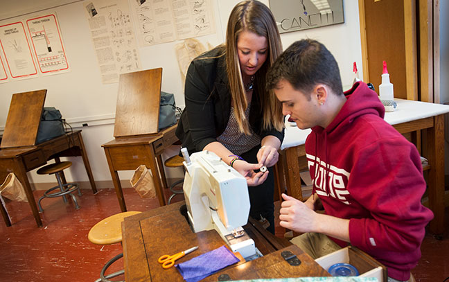two students work with a sewing machine
