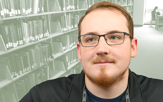 A student being superimposed in front of a green background showing what looks like the inside of a library.