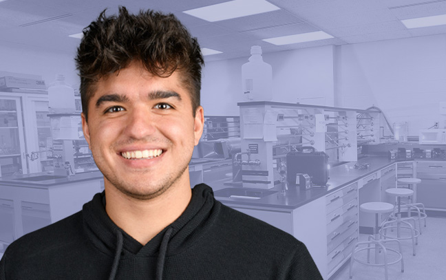 A student being superimposed in front of a blue-violet background showing a laboratory.