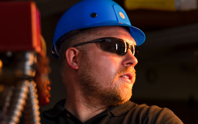a close up of a man in a hard hat looking off to the side