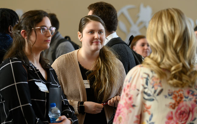 couple of female students chatting with another blond lady during the event during the class