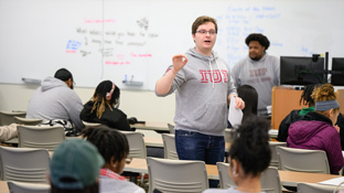 a professor wearing an IUP shirt leads a classroom of students