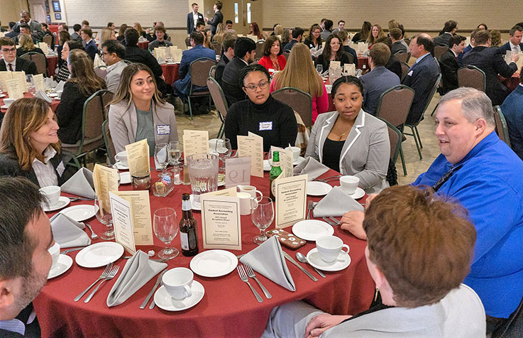 Following the mingling session, students, faculty, and professionals were seated together at each table for a buffet-style dinner. From left: Lisa Sciulli, professor, Department of Marketing; Maura Wilkinson ’18, risk and financial advisory senior consultant, Deloitte-Pittsburgh; Zipporah Prescott, sophomore; Tahirah Arter, sophomore, and Mike Cecotti ’98, chief accounting officer, Norilsk Nickel USA, Inc. 